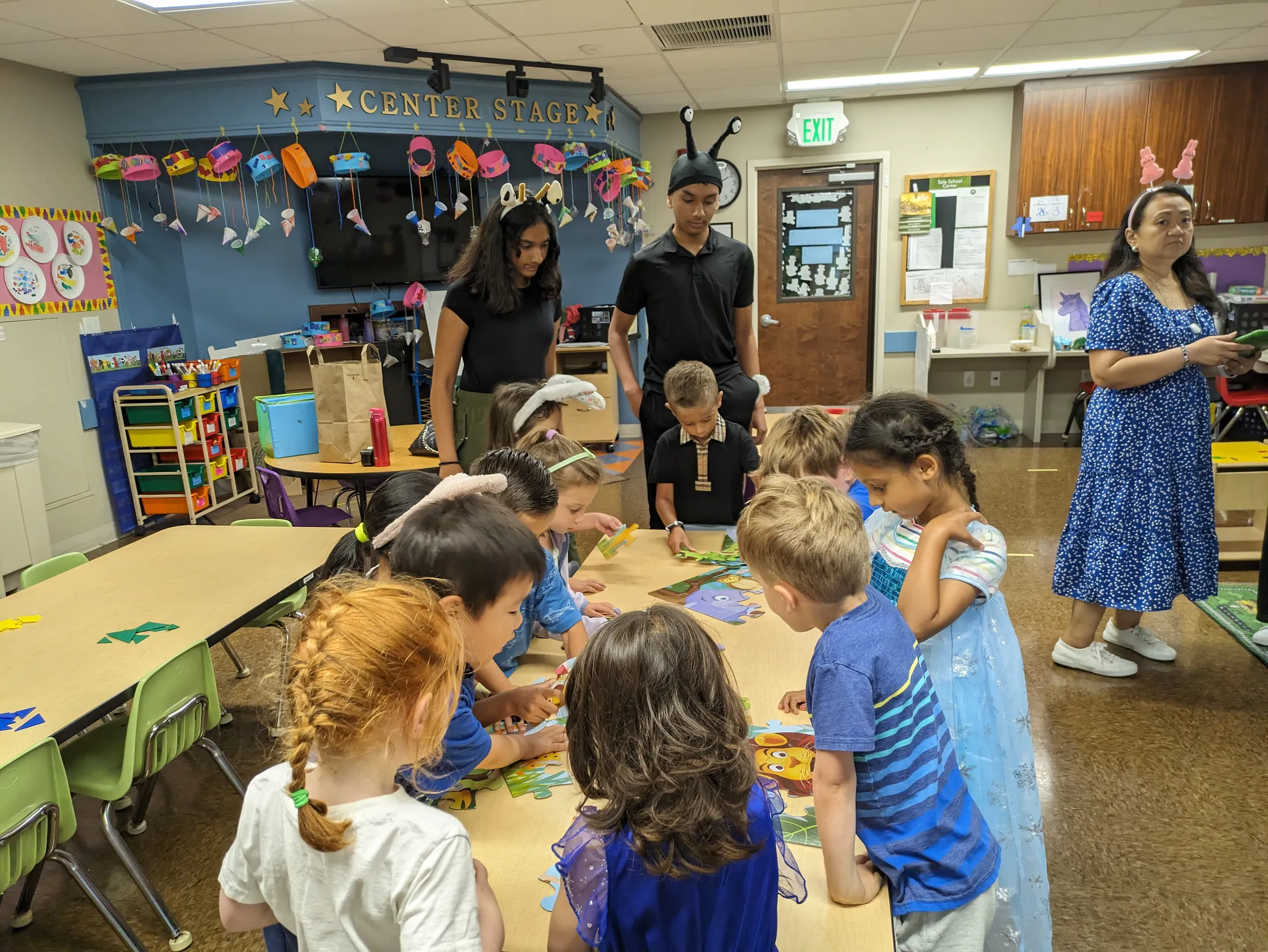 Children crowded around a classroom table piecing together a puzzle