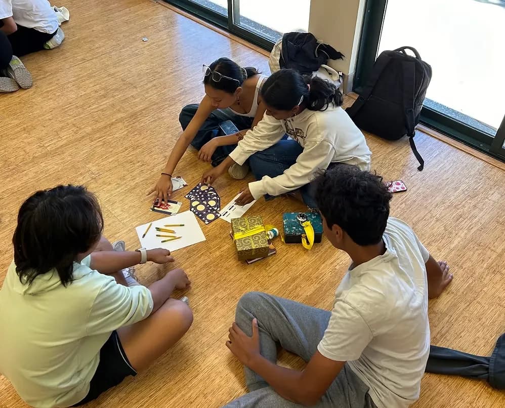 Players kneeling on a hall floor working a puzzle box open